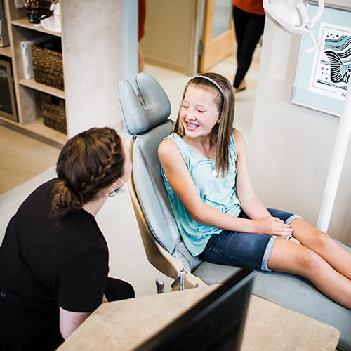Little girls smiling while sitting in the dentist chair