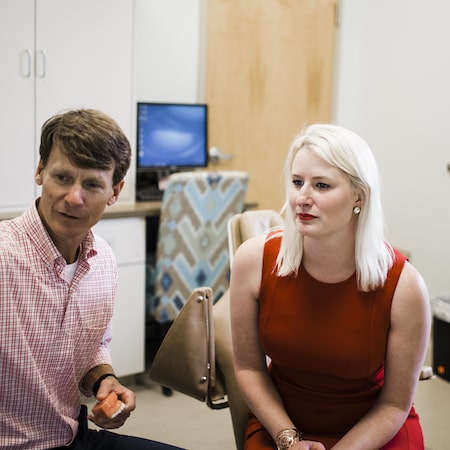 Dr. Lucas explaining a Nashville orthodontic treatment to a woman in a red dress