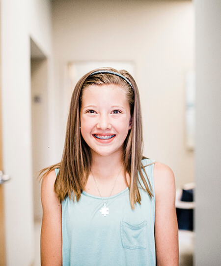 A young patient smiling with braces on